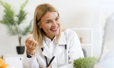 爱荷华州 family nurse practitioner smiling with pediatric patient during appointment